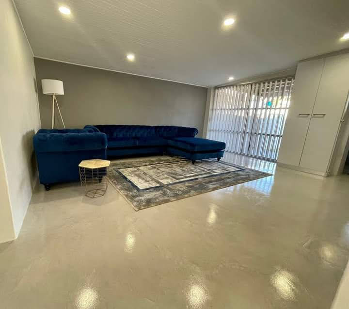 Warm grey colour screed floor with a soft sheen in a furnished lounge