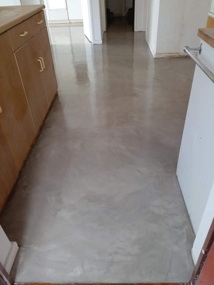 Grey screed with soft cloudy movement running from a kitchen into a passage